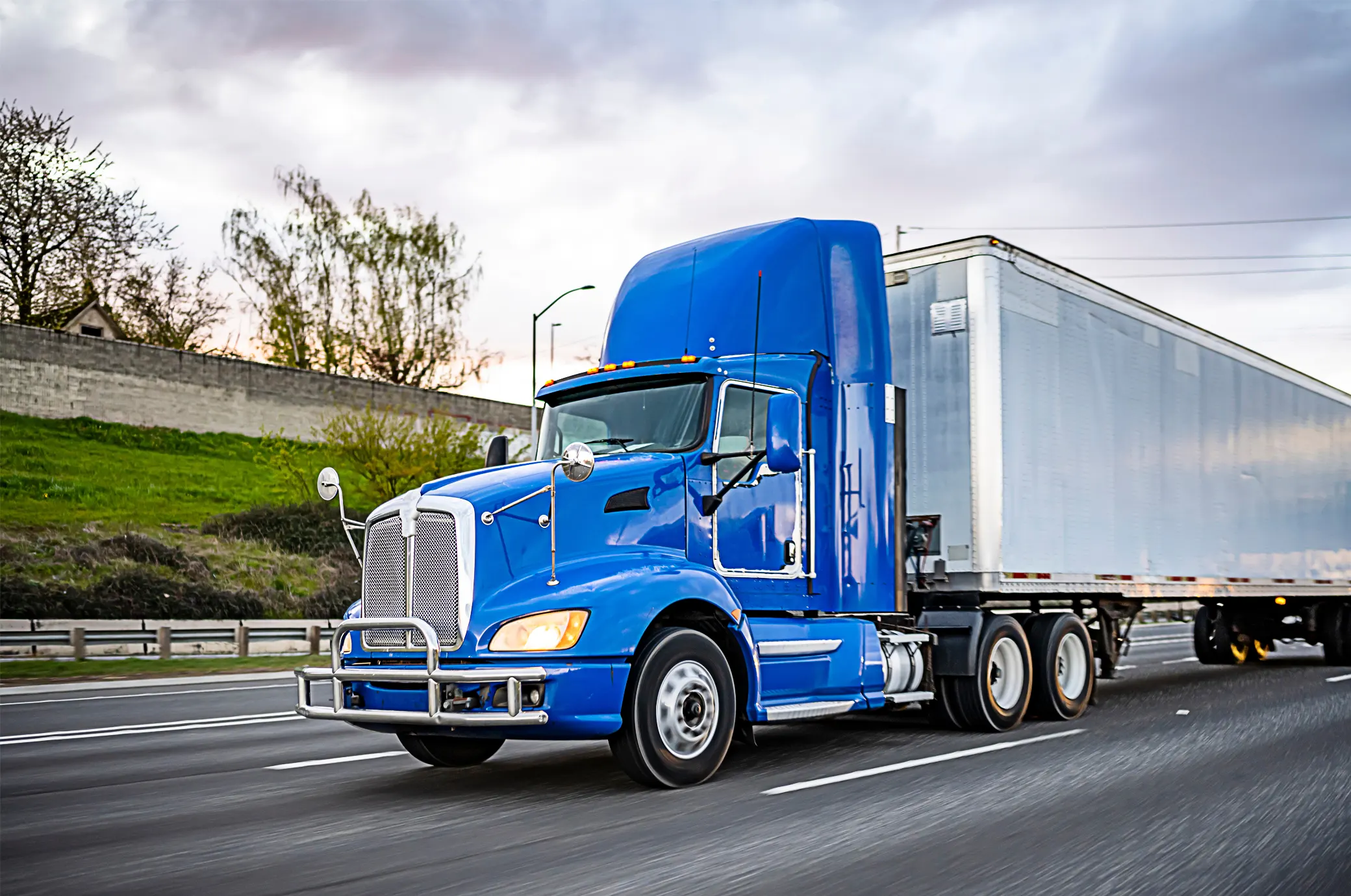 blue_truck_aboutus Blue semi-truck on highway, representing Highway Driver Leasing's CDL driver staffing services in New England.